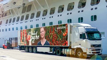 Ein Foodservice Lkw von Gemüsering, der mit frischem Obst und Gemüse beladen ist, steht neben einem Kreuzfahrtschiff, bereit zur Lieferung